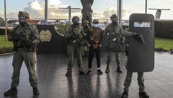 Fotografía sin fecha publicada por la Policía Nacional de Colombia de sus miembros de pie junto al presunto narcotraficante del Clan del Golfo, alias Matamba (C), después de su captura en Bogotá. (Foto: Colombian National Police / AFP)