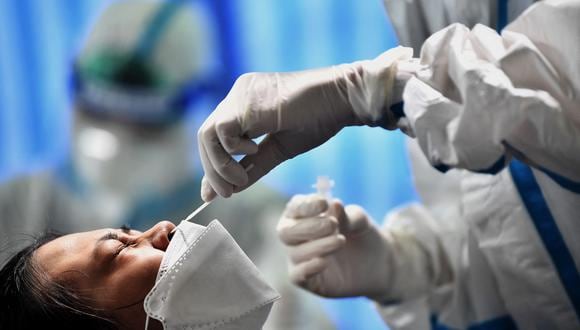 Un test de covid realizado a una persona en Bangkok. (Foto: Lillian SUWANRUMPHA / AFP)