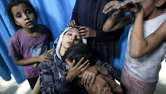 Una mujer palestina herida de la familia Baraka está rodeada de sus hijos en el Hospital Nasser en Jan Yunis, en el sur de la Franja de Gaza, el 13 de noviembre de 2023. (Foto de Mahmud HAMS / AFP)