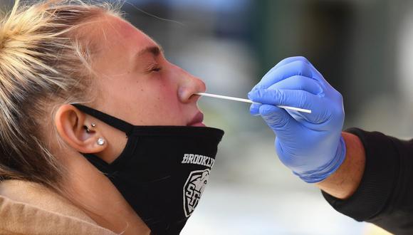 Personal sanitario toma una muestra de un hisopo nasal a una estudiante para realizar una prueba de coronavirus COVID-19 en Nueva York. (Foto: Angela Weiss / AFP).