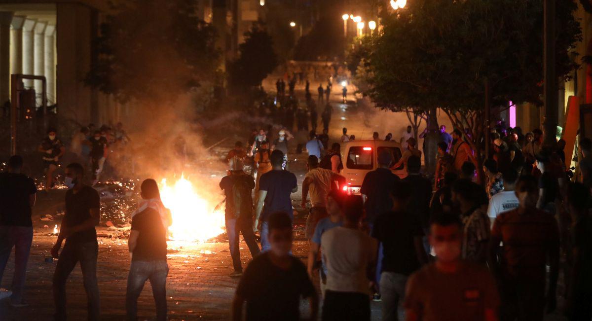 Los manifestantes se encuentran cerca del fuego durante una protesta cerca del parlamento, luego de la explosión del martes en el área del puerto de Beirut, Líbano. (Foto: REUTERS / Mohamed Azakir).