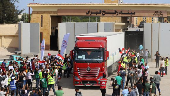 Los trabajadores humanitarios egipcios celebran mientras un camión cruza de regreso a Egipto a través del cruce fronterizo de Rafah con la Franja de Gaza el 21 de octubre de 2023. (Foto de Kerolos Salah / AFP)