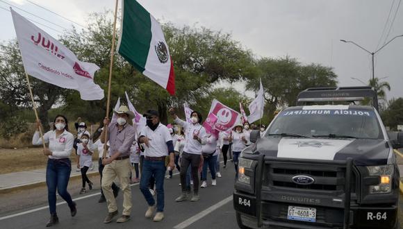 El candidato independiente Julio González sostiene una bandera de México mientras camina con sus partidarios en Dolores Hidalgo, estado de Guanajuato, el 5 de mayo de 2021. (Foto de ALFREDO ESTRELLA / AFP).
