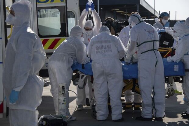 El personal médico carga a un paciente infectado con el nuevo coronavirus, Covid-19, en un avión militar A400M para transportarlo desde el aeropuerto de Orly, al sur de la capital, a un hospital fuera de la región de París (Foto: Bertrand Guay / AFP)