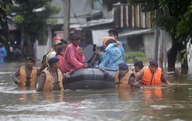 La policía de Indonesia usa un bote de goma para evacuar a residentes de Yakarta. (EFE / EPA / ADI WEDA).