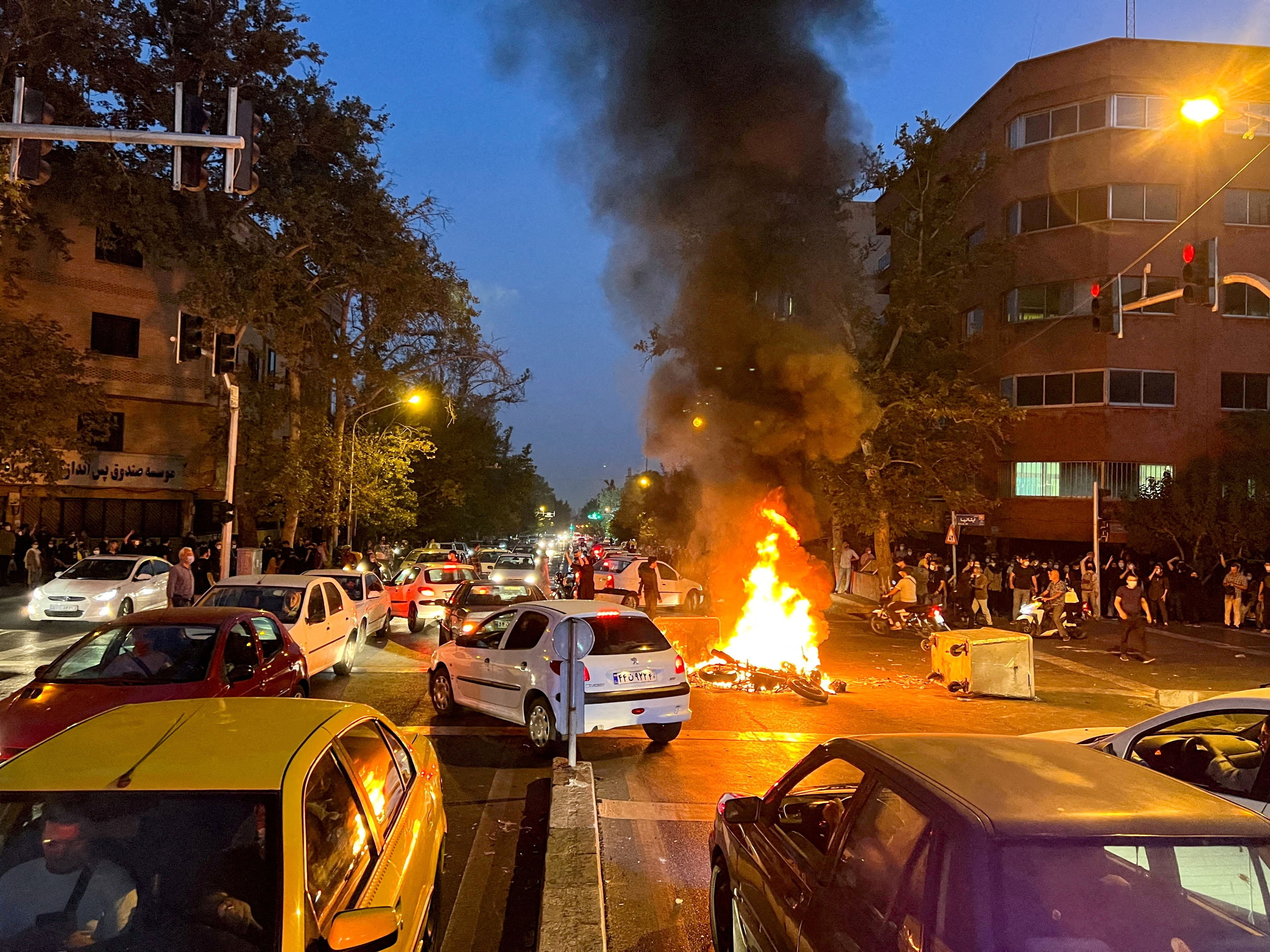 In this September 19 photo, protesters burn a police motorcycle in the heart of Tehran.  Those arrested for participating in the protests are being sentenced to death.  (West Asia News Agency) via REUTERS/File Photo/File Photo