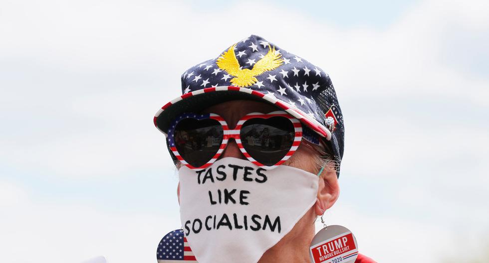 Una seguidora del presidente Trump lleva una mascarilla que dice "Sabe a socialismo", en una manifestación en Massachussetts contra el cierre de los negocios por la cuarentena. (Reuters)