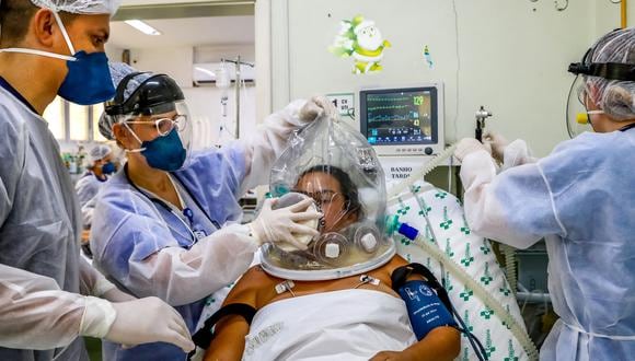 A patient uses a new non-invasive technology that can reduce the need of intubation at the COVID-19 area of the Centenario Hospital in Sao Leopoldo, Rio Grande do Sul state, southern Brazil, on April, 16, 2021. - It is the individually controlled breathing bubble. The impermeable, transparent, sealed and inflatable bubble has respiratory connections that allow pulmonary oxygenation, reducing the patient's effort without the need for sedation. (Photo by SILVIO AVILA / AFP)