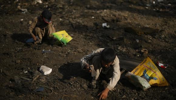 Niños hurgan en busca de chatarra en Kabul el 26 de julio de 2022 (Foto de Daniel LEAL / AFP / IMAGEN REFENCIAL)