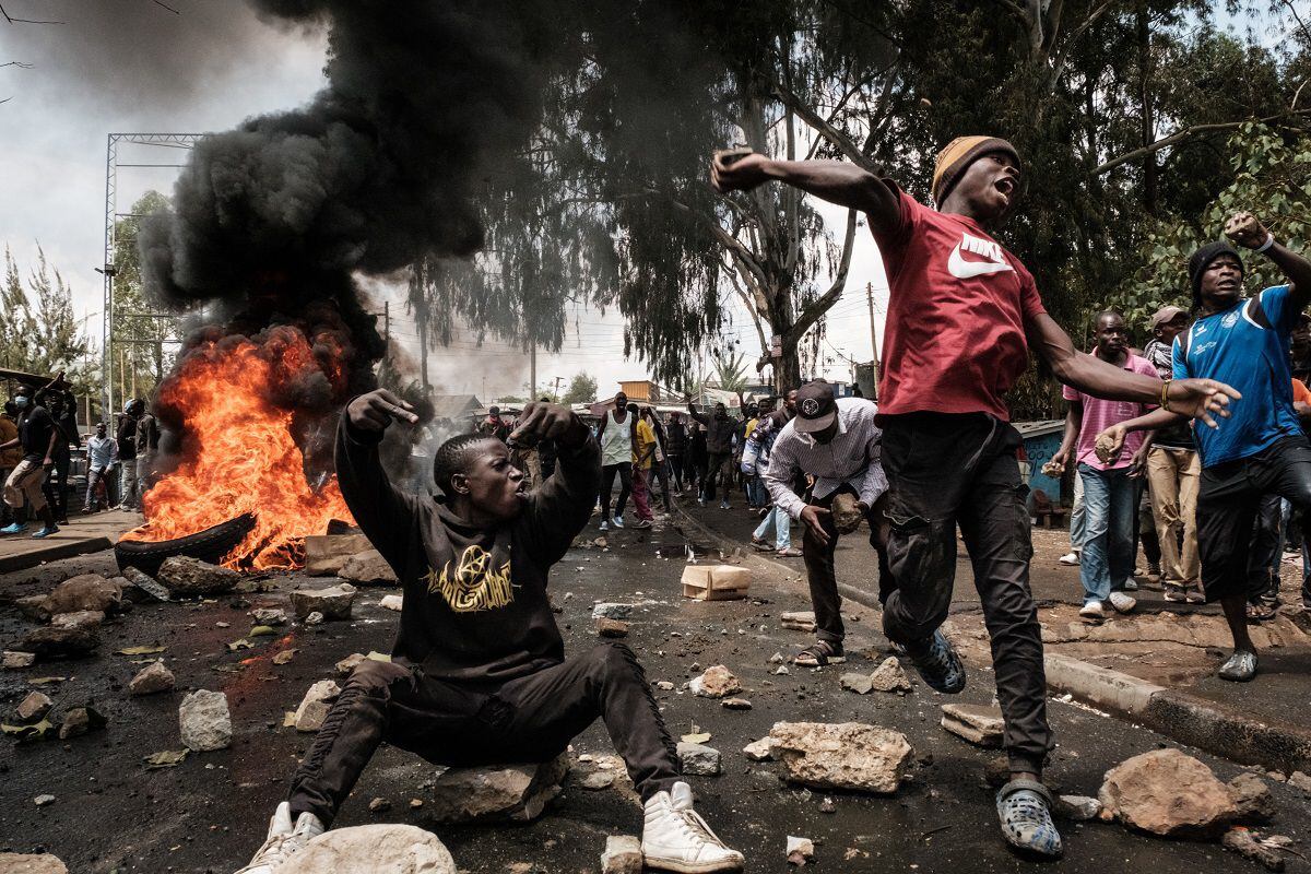 Protesters throw stones at police officers and a water cannon vehicle in Kibera, Nairobi, on March 20, 2023. (Photo by YASUYOSHI CHIBA/AFP)