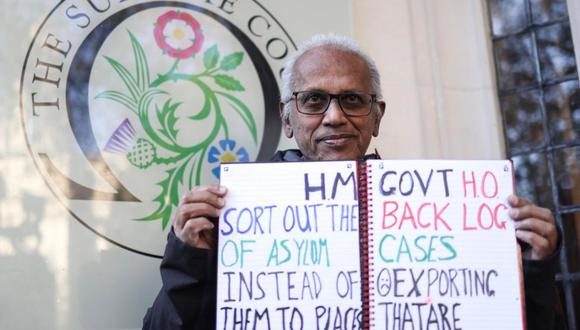 Un manifestante sostiene un cartel mientras protesta contra la política del gobierno de deportar a los solicitantes de asilo a Ruanda, frente al Tribunal Supremo del Reino Unido en Londres, Gran Bretaña, el 15 de noviembre de 2023 | Foto: EFE/EPA/NEIL HALL