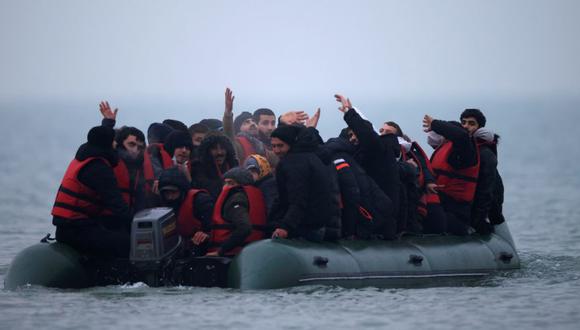 Un grupo de más de 40 migrantes reacciona al conseguir subirse a un bote inflable, dejar la costa del norte de Francia y cruzar el Canal de la Mancha, cerca de Wimereux, Francia, el 24 de noviembre de 2021. (Foto: REUTERS / Gonzalo Fuentes).