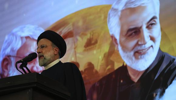 El presidente iraní, Ebrahim Raisi, se dirige a una ceremonia que marca el aniversario de la muerte del difunto general de la Guardia Revolucionaria Qassem Soleimani, que se muestra en el cartel de fondo. (AP/Vahid Salemi)