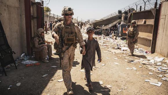 En esta imagen proporcionada por el Cuerpo de Marines de Estados Unidos, los soldados ayudan durante las evacuaciones en curso en el Aeropuerto Internacional Hamid Karzai, Kabul, Afganistán, el martes 24 de agosto de 2021. (Cuerpo de Marines de EE.UU. Vía AP).