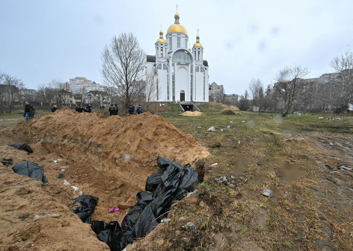 A mass grave is seen behind a church in the town of Bucha, northwest of the Ukrainian capital kyiv, on April 3, 2022. (SERGEI SUPINSKY/AFP)
