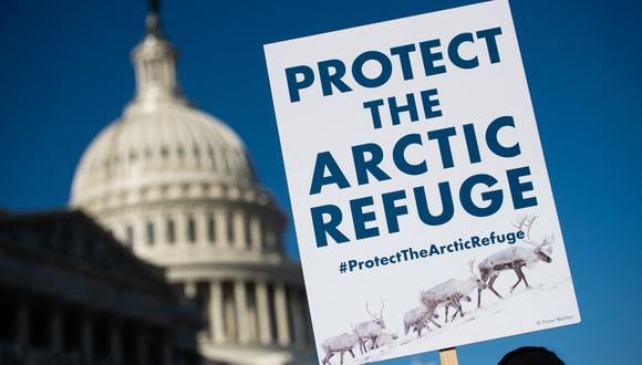 Un manifestante sostiene un cartel contra la perforación en el Refugio Ártico en el 58º aniversario del Refugio Nacional de Vida Silvestre del Ártico. (Foto de SAUL LOEB / AFP)