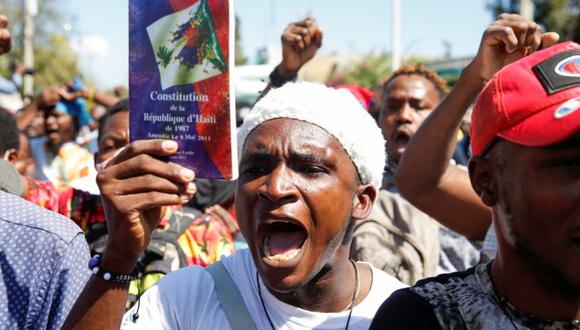 Un manifestante sostiene una copia de la Constitución de Haití durante una protesta contra el presidente de Haití, Jovenel Moise, en Puerto Príncipe, Haití. (Foto: REUTERS / Jeanty Junior Augustin).