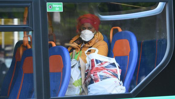 Coronavirus. Una mujer usa máscara protectora en un bus de transporte público en Manchester, Reino Unido. Foto: AFP.