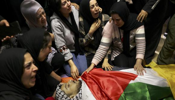 Mujeres palestinas lloran por el cuerpo de Anas al-Froukh, quien recibió un disparo junto con su primo durante una incursión de las tropas de Israel en Sair, al este de Hebrón, en Cisjordania. (Foto de HAZEM BADER / AFP).