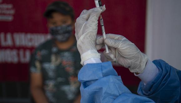Personal de la salud se prepara para inocular a un niño con una vacuna contra el COVID-19, en Lima, el 25 de enero de 2022. (Foto de ERNESTO BENAVIDES / AFP)