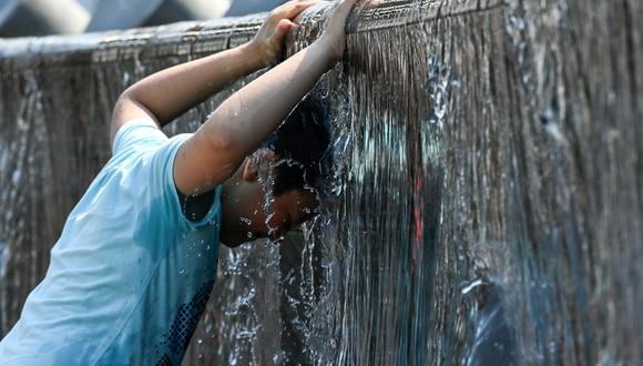 A boy cools off in a fountain during a hot summer day in downtown Moscow on July 13, 2021. - Russia's meteorological service said on July 13, 2021 the country could see its hottest summer on record, driven by climate change, after a record-breaking heatwave in June. Moscow was hit by a historic heat wave at the end of June, with temperatures reaching a 120-year record. (Photo by Kirill KUDRYAVTSEV / AFP)