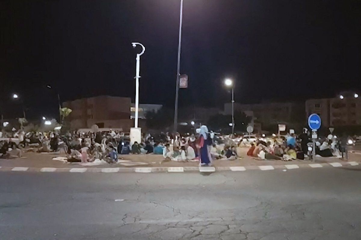 This frame grab from a video taken by AFPTV shows people outdoors in Marrakesh on September 9, 2023, following a magnitude 7 earthquake that hit Morocco.  (Photo by Faisal Baddour / AFPTV / AFP)
