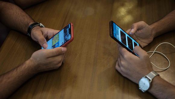 Los escolares tienen que hacer sus trabajos en celulares a falta de computadoras. (AFP)