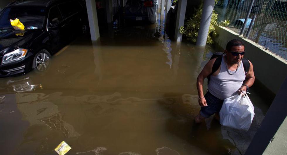 Un hombre sale del estacionamiento de un edificio inundado debido a las intensas lluvias registradas el pasado fin de semana, hoy, en Cataño (Puerto Rico). (EFE/ Thais LLorca).