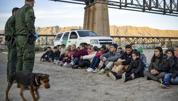 En esta foto de archivo, un grupo de unos 30 migrantes brasileños, que acababan de cruzar la frontera, se sientan en el suelo cerca de los agentes de la Patrulla Fronteriza de Estados Unidos. (Foto de Paul Ratje / AFP).