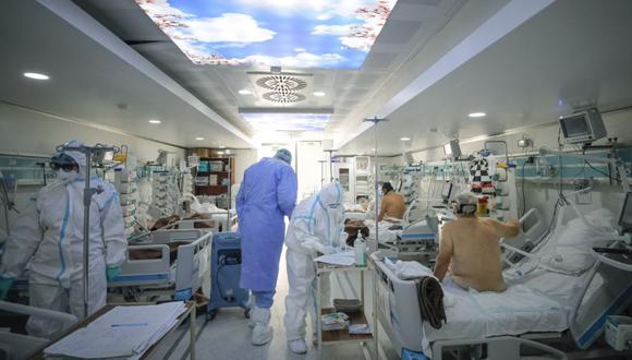 Medical staff attend to COVID-19 patients in a mobile ICU unit, set up on the hospital grounds to cope with the high numbers of seriously ill people at the Marius Nasta National Pneumology Institute in Bucharest, Romania, Wednesday, Oct. 6, 2021.  (AP Photo/Andreea Alexandru)