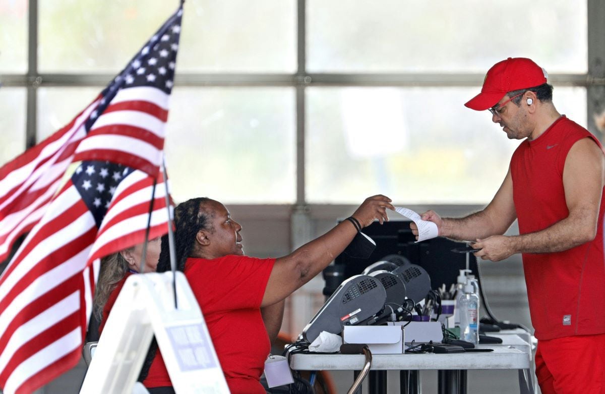 A voter receives a receipt from a clerk after delivering their ballot for the midterm elections at a polling place in Kissimmee, Florida, on November 8, 2022. (Gregg Newton / AFP)
