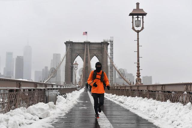 Un hombre camina sobre el puente de Brooklyn en el distrito en Nueva York el 2 de febrero de 2021 en medio de una gran tormenta de nieve. (Foto de Angela Weiss / AFP).