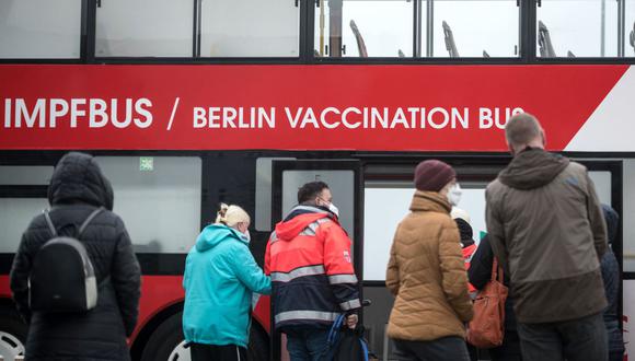 La gente se para frente a un autobús de vacunación contra el coronavirus COVID-19 en Berlín, Alemania, en medio de la nueva ola de contagios de coronavirus. (STEFANIE LOOS / AFP).