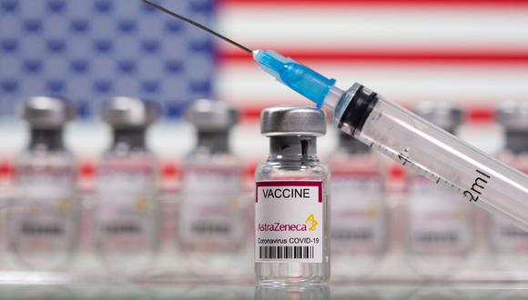 En esta ilustración, tomada el 10 de marzo de 2021, se ven frascos con la etiqueta "Vacuna contra el coronavirus AstraZeneca" y una jeringa frente a una bandera de Estados Unidos. (REUTERS/Dado Ruvic).