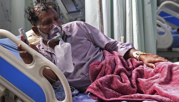 Un paciente de coronavirus Covid-19 respira con la ayuda de una máscara de oxígeno dentro de la Unidad de Cuidados Intensivos (UCI) del hospital de la Universidad Teerthanker Mahaveer (TMU) en Moradabad, India. (Foto de Prakash SINGH / AFP).