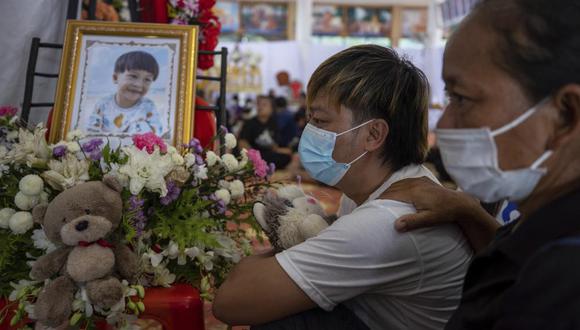 Familias ofrecen flores, muñecos, palomitas de maíz y cajitas de jugo a las almas de los niños asesinados en una guardería en Tailandia, como parte de una ceremonia budista.