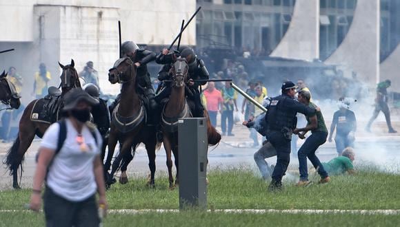 Los partidarios del expresidente brasileño Jair Bolsonaro chocan con las fuerzas de seguridad durante una invasión al Palacio Presidencial del Planalto en Brasilia.