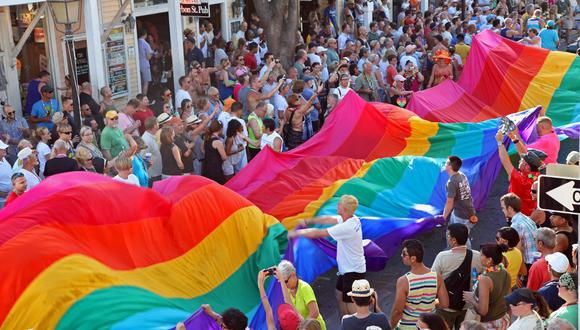 Un grupo de personas sostiene una bandera del arcoíris, símbolo del orgullo gay, en Duval Street, Key West, Florida. (Foto referencial: Carol Tedesco / OFICINA DE NOTICIAS DE FLORIDA KEYS / AFP).