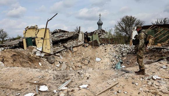 Un soldado ucraniano observa el cráter dejado por un misil que destruyó una casa en la villa de Yatskivka, al este de Ucrania.