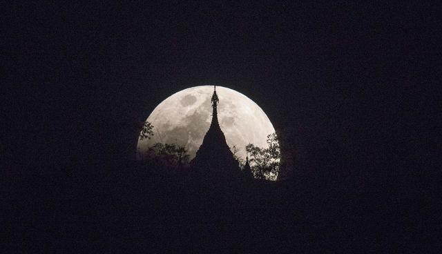 The moon rises over a pagoda in Kumal, some 105 kms away from Mandalay City on January 31, 2018.  Skywatchers were hoping for a rare lunar eclipse that combines three unusual events -- a blue moon, a super moon and a total eclipse -- which was to make for a large crimson moon viewable in many corners of the globe. / AFP / YE AUNG THU