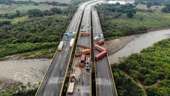 Esta vista aérea muestra a trabajadores estatales venezolanos retirando contenedores en el puente internacional "Tiendita" en la frontera entre Colombia y Venezuela en Cúcuta, Colombia.