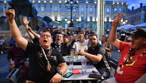 Los aficionados del club Lyon reaccionan en la terraza de un bar en Lyon, el 19 de agosto de 2020, mientras ven el partido de fútbol de la semifinal de la UEFA Champions League. (Foto de PHILIPPE DESMAZES / AFP).
