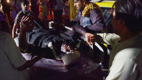 El personal médico y hospitalario lleva a un hombre herido en una camilla para recibir tratamiento después de dos explosiones frente al aeropuerto de Kabul, Afganistán, el 26 de agosto de 2021. (Wakil KOHSAR / AFP).