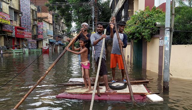 Las personas usan una balsa improvisada para mudarse de un vecindario inundado en Patna. (Foto: Reuters)