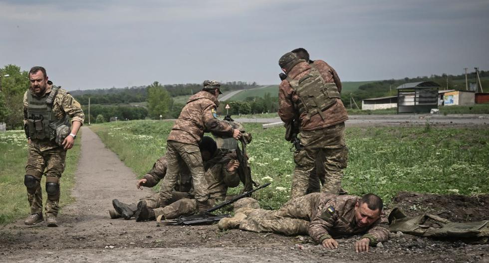 Los militares ucranianos ayudan a sus camaradas cerca de la línea del frente en la región oriental del Donbás, en Ucrania, el 21 de mayo de 2022. (AFP).