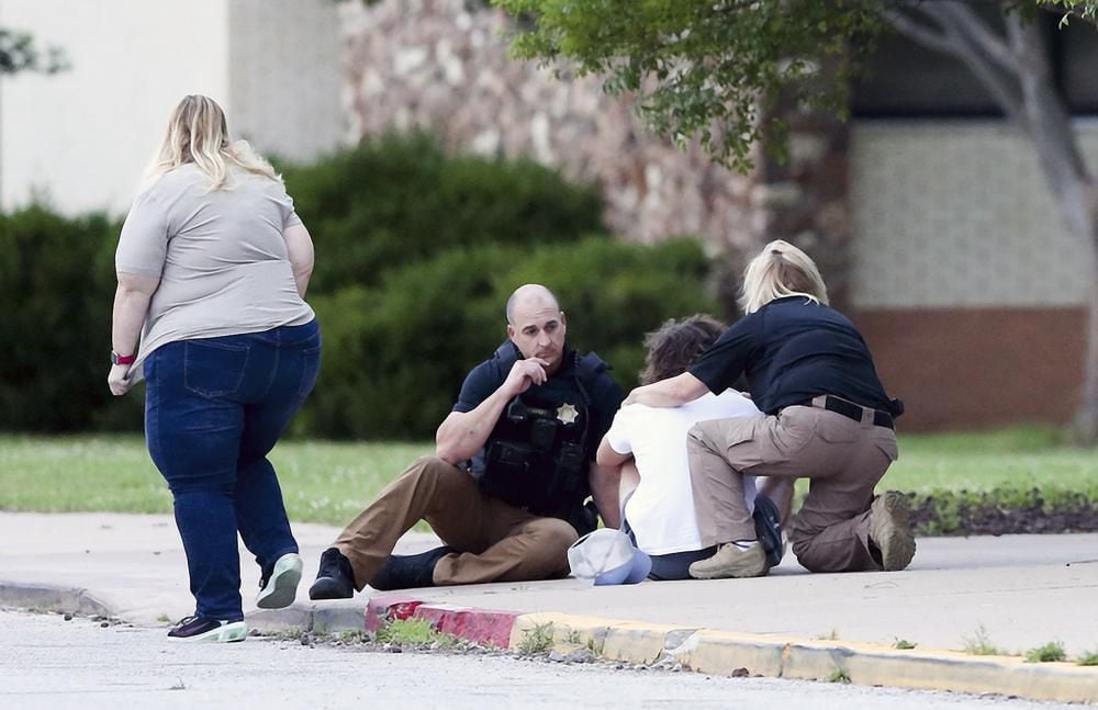 Two people hug outside Memorial High School, where people were evacuated from the scene of a shooting at the Natalie Medical Building in Tulsa, Oklahoma.  (Ian Maule/Tulsa World via AP)