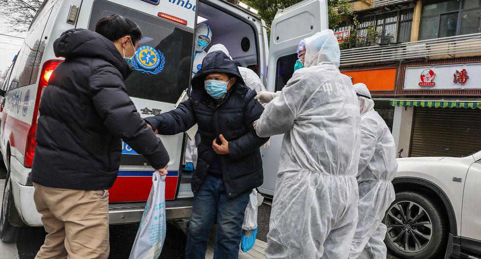 La imagen muestra a una persona sospechosa de portar el coronavirus siendo trasladada por trabajadores de salud en China. (Foto: AFP)