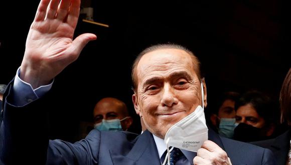 El ex primer ministro de Italia, Silvio Berlusconi, se saca la mascarilla y saluda con la mano cuando llega al Palacio de Montecitorio para las conversaciones sobre la formación de un nuevo gobierno, en Roma, Italia, el 9 de febrero de 2021. (REUTERS/Yara Nardi).