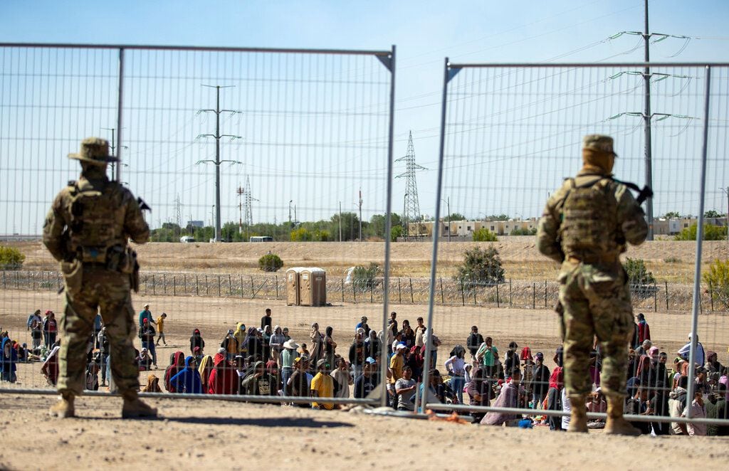 Migrants wait near a border fence under surveillance by the Texas National Guard, United States, on May 10, 2023. (AP Photo/Andrés Leighton).