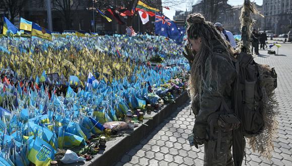 Una militar ucraniana se encuentra frente a un monumento improvisado para los soldados ucranianos caídos en la Plaza de la Independencia en el Día Internacional de la Mujer en Kiev, el 8 de marzo de 2024, en medio de la invasión rusa de Ucrania. (Foto de Genya SAVILOV / AFP)